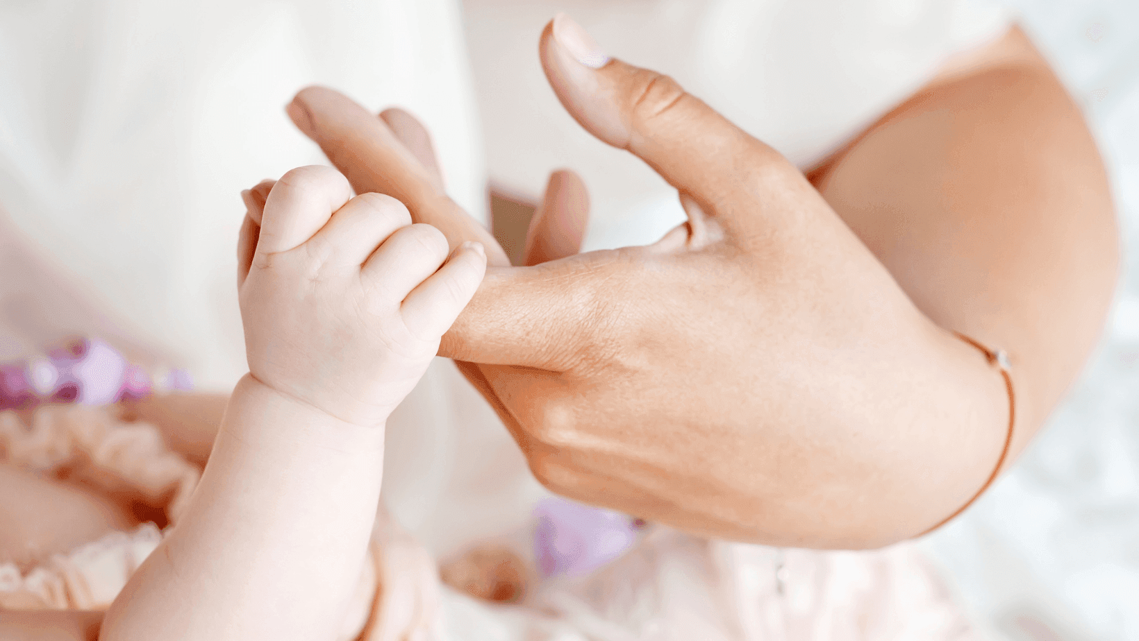 Miminko se drží za ruku.